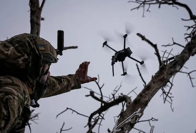 Ukrainian serviceman launches a kamikaze FPV drone at a front line, amid Russia's attack on Ukraine, near the city of Bakhmut in Donetsk region, Ukraine on December 12, 2023. (Photo by Inna Varenytsia/Reuters)