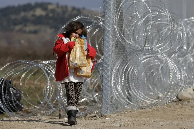 A migrant child from Afghanistan carries food next to a border fence at the Macedonian-Greek border in Gevgelija, Macedonia February 23, 2016. (Photo by Marko Djurica/Reuters)