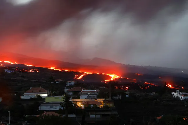 Lava from the Cumbre Vieja volcano flows as seen from Tajuya on the Canary Island of La Palma, Spain, October 19, 2021. (Photo by Susana Vera/Reuters)
