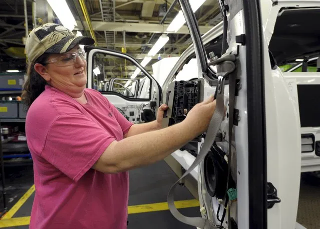 Auto worker Melinda Barnett installs components into a F150 at Ford's Kansas City Assembly Plant where new aluminum intensive Ford F-Series pickup is built in Claycomo, Missouri May 5, 2015. (Photo by Dave Kaup/Reuters)