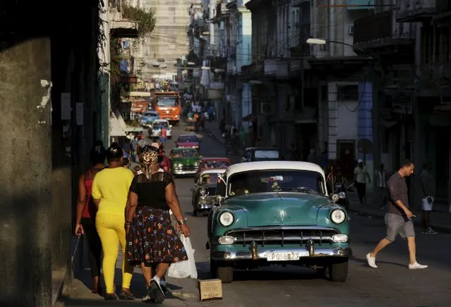 A 1954 Chevrolet car used as a taxi drives as people walk on a street in Havana March 16, 2016. (Photo by Enrique de la Osa/Reuters)