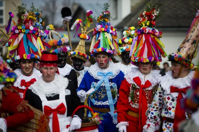 Men dressed in a traditional carnival costume walk from house to house during the traditional folklore carnival parade on March 1, 2014 in Vortova, Czech Republic. Masked revellers walk with a musical band through the village house by house to celebrate the departing winter, forthcoming spring and start of forty-day Lent. (Photo by Matej Divizna/Getty Images)