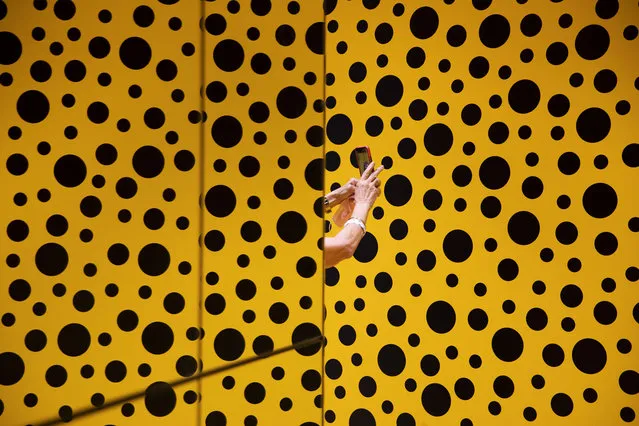 A woman takes a photo during her visit at the art work “The Spirits of the Pumpkins Descended into the Heavens” by Yayoi Kusama, part of retrospective exhibition in the Tel Aviv Museum of Art, Israel, Monday, November 15, 2021. (Photo by Oded Balilty/AP Photo)