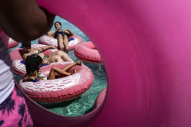 Visitors float on pink colored inflatable tubes at the Parque Dunas water park in Valencia, Venezuela, Sunday, January 28, 2024. (Photo by Matias Delacroix/AP Photo)