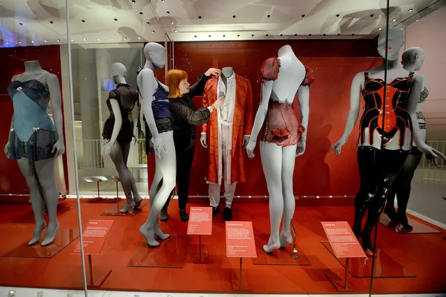 A museum worker adjusts lingerie  during the press preview of Undressed: A Brief History of Underwear at the Victoria and Albert museum, in London, Tuesday April 12, 2016. Think of it as Victoria's (and Albert's) secret. London's Victoria and Albert Museum has peeled back fashion's layers to expose everything from long johns to lingerie in “Undressed”, an exhibition tracing the hidden history of underwear. (Photo by Anthony Devlin/PA Wire via AP Photo)