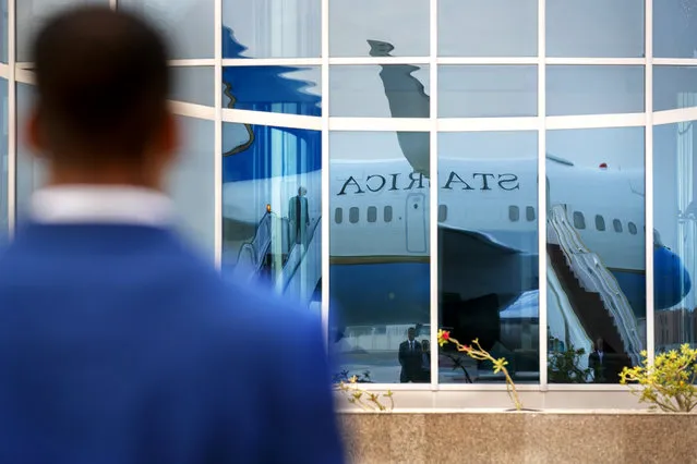 A member of Diplomatic Security stands guard on the tarmac as the plane for Secretary of State Mike Pompeo is reflected in a glass building, in preparation for Pompeo's departure from Abu Dhabi, United Arab Emirates, Tuesday, June 25, 2019, from where he will head to an undisclosed location. (Photo by Jacquelyn Martin/AP Photo/Pool)