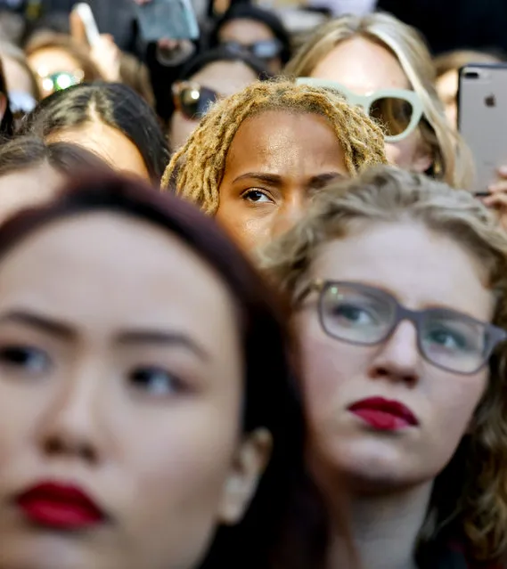 Participants listen to remarks from a speaker at the International Women's Day rally in the shadow of New York's Trump Tower, Wednesday March 8, 2017, in New York.  The protest was part of a nationwide event called A Day Without a Woman. Many of the participants had taken a day off from work to show the impact women have on the American economy. (Photo by Bebeto Matthews/AP Photo)