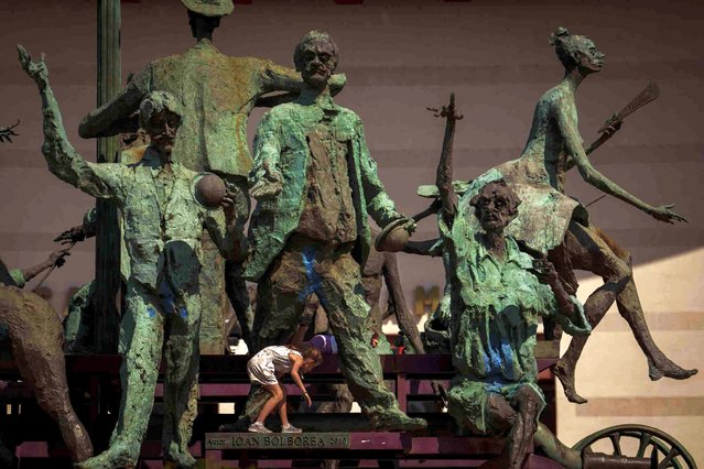 A child plays on a group of statues outside the National Theatre, in Bucharest, Romania, Saturday, April 13, 2024. (Photo by Vadim Ghirda/AP Photo)