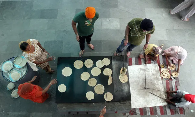 Devotees make chapattis or bread at a community kitchen in a Gurudwara or a Sikh temple during Baisakhi festival in Noida on the outskirts of New Delhi April 14, 2012. Sikhs celebrate Baisakhi, a harvest festival, as the beginning of the New Year. (Photo by Parivartan Sharma/Reuters)