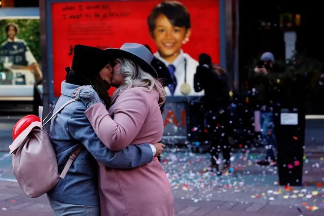 Emma Adams and Sarah Malbon, both from Staffordshire, England, kiss after their marriage proposal at Times Square in New York City, U.S., February 14, 2022. (Photo by Shannon Stapleton/Reuters)
