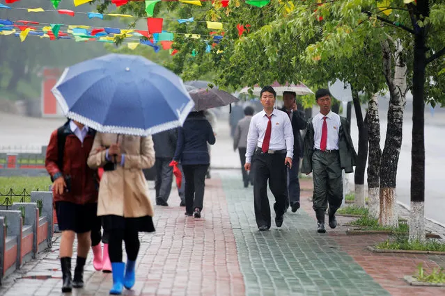 People walk in the rain near April 25 House of Culture, the venue of Workers' Party of Korea (WPK) congress in Pyongyang, North Korea May 6, 2016. (Photo by Damir Sagolj/Reuters)