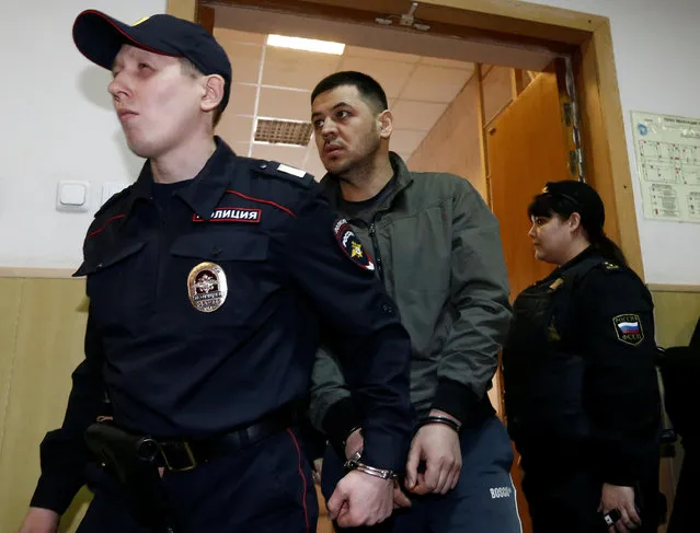 Sadik Ortikov, suspected in being involved in the blast in St. Petersburg metro, is escorted by police officers during a hearing on his detention at Basmanny District Court of Moscow, in Moscow, Russia, April 7, 2017. (Photo by Sergei Karpukhin/Reuters)