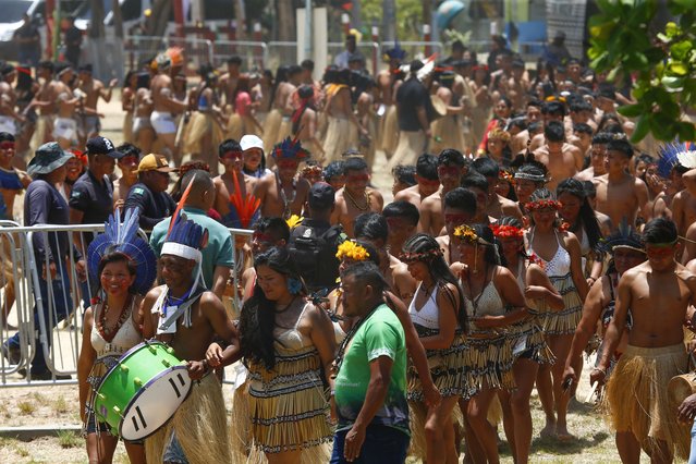 Indigenous people dance at the Caracarana Lake Regional Center in Normandia, on the Raposa Serra do Sol Indigenous reserve in Roraima state, Brazil, Monday, March 13, 2023. Hundreds of indigenous leaders from several ethnicities are meeting to discuss their rights, environment, sustainability, land demarcation and illegal mining. (Photo by Edmar Barros/AP Photo)