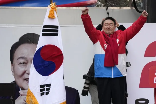Yoon Suk Yeol, the presidential candidate of the main opposition People Power Party, raises his hands during a presidential election campaign in Seoul, South Korea, Tuesday, February 15, 2022. Candidates kicked off official campaign on Tuesday for South Korea's presidential election on March 9. (Photo by Ahn Young-joon/AP Photo)