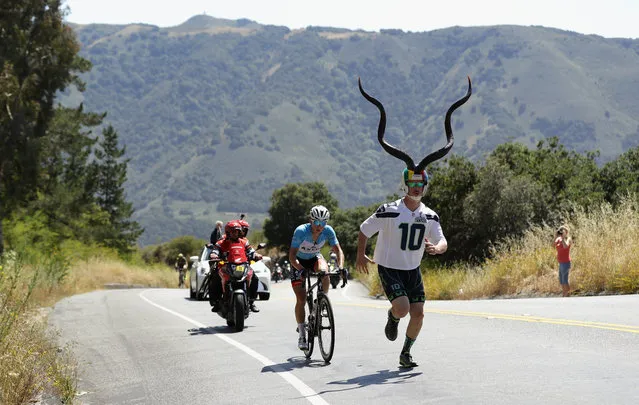 A fan runs alongside Gregory Daniel of the United States as he rides during Stage 4 of the Amgen Tour of California on on May 18, 2016 in Salinas, California. (Photo by Ezra Shaw/Getty Images)