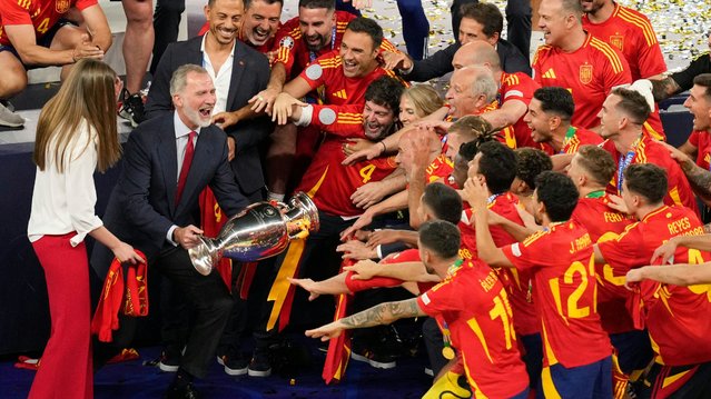 Spanish King Felipe VI holds the trophy as he and his daughter Princess Sofia celebrate with the players they won the final match between Spain and England at the Euro 2024 soccer tournament in Berlin, Germany, Sunday, July 14, 2024. (Photo by Andreea Alexandru/AP Photo)