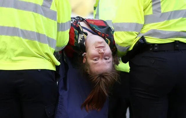 Police takes away a demonstrator during an Extinction Rebellion climate activists' protest, at Oxford Circus, in London, Britain on August 25, 2021. (Photo by Henry Nicholls/Reuters)