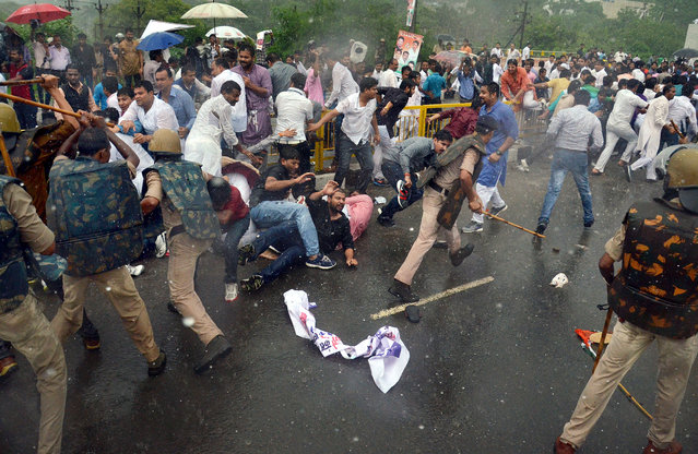 Police personnel baton charge protesters to control the mob during Indian Youth Congress workers protest against Madhya Pradesh Chief Minister Shivraj Singh Chouhan against the series of deaths in Madhya Pradesh Professional Examination Board or VYAPAM scam, in Bhopal, India, 23 July 2015. More than 40 people associated with the admission and recruitment racket in Vyapam or the Madhya Pradesh Professional Examination Board have died since 2013 – either in mysterious circumstances or have committed suicides. (Photo by Sanjeev Gupta/EPA)