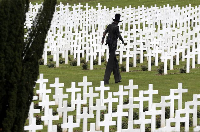 A performer depicting death walks amongst tombstones at the French National cemetery outside the Douaumont Necropolis and Ossuary, France, May 29, 2016, during a ceremony marking the 100th anniversary of the battle of Verdun, one of the largest battles of the First World War (WWI) on the Western Front. (Photo by Philippe Wojazer/Reuters)