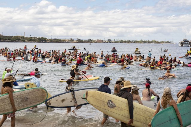 Hundreds of surfers paddle out into the waters of Hanakaoʻo Park as part of the ceremony marking the one-year anniversary of the Lahaina wildfire on Thursday, August 8, 2024, in Lahaina, Hawaii. (Photo by Mengshin Lin/AP Photo)