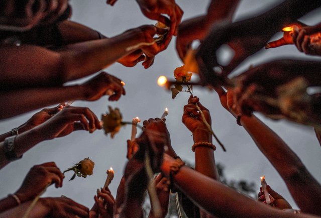 Congolese civilians hold candles to pay tribute to the victims killed by rains that destroyed the remote, mountainous area and ripped through the riverside villages of Nyamukubi, Kalehe territory in South Kivu province, during a vigil in Goma, Democratic Republic of Congo on May 9, 2023. (Photo by Reuters/Stringer)