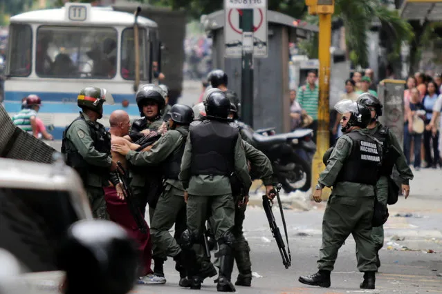 Venezuelan National Guards detain a protester during riots for food in Caracas, Venezuela, June 2, 2016. (Photo by Marco Bello/Reuters)