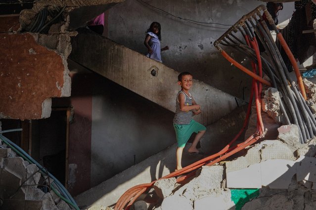 Members of Ibrahim Abu Alya's family climb the stairs inside their house heavily damaged by Israeli bombardment, in the town of Bani Suheila near Khan Yunis in the southern Gaza Strip on July 17, 2024, amid the ongoing conflict between Israel and the Palestinian militant group Hamas. (Photo by Bashar Taleb/AFP Photo)