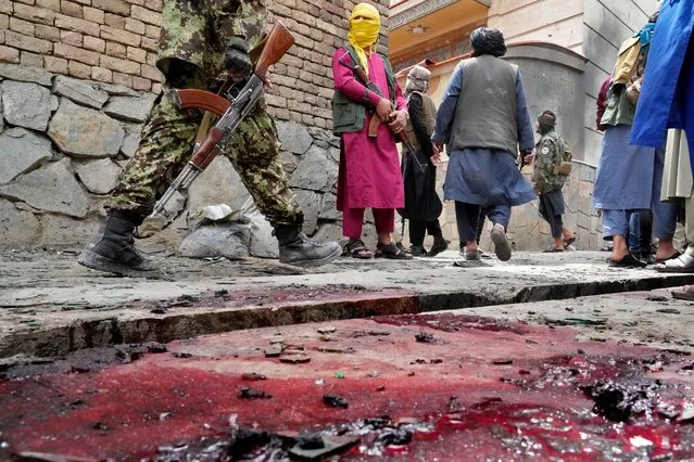 Taliban fighters stand guard at the site of an explosion in front of a school, in Kabul, Afghanistan, Tuesday, April 19, 2022. An Afghan police spokesman says explosions targeting educational institutions in Kabul have killed at least six civilians and injured over 10 others. Khalid Zadran said Tuesday the blasts occurred in the mostly-Shiite Muslim area in the west of Afghanistan's capital. (Photo by Ebrahim Noroozi/AP Photo)