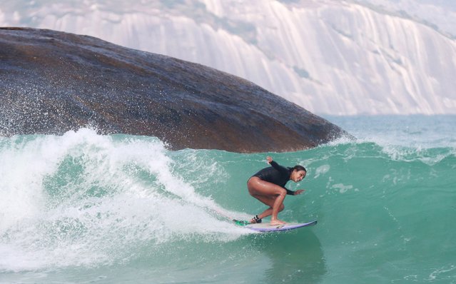 A young woman prepares to execute a “Barrel”,' also referred to as tubing or getting pitted, at Arpoador in Rio de Janeiro on June 28, 2024. Barreling involves riding inside the hollowed-out face of a wave, making it one of the most exhilarating and demanding maneuvers in surfing. The peak season for this thrilling experience is winter, marked by predominantly left-hand waves that can be enjoyed across all tide conditions. (Photo by Bob Karp/ZUMA Press Wire/Alamy Live News)