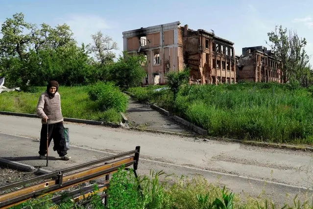 An elderly woman walks in Mariupol on May 31, 2022, amid the ongoing military action in Ukraine. (Photo by AFP Photo/Stringer)