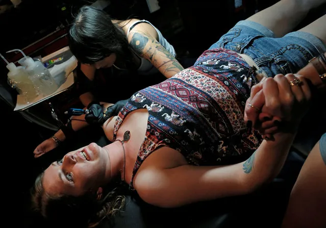 Lauryn Hughes reacts as she gets a tattoo from Kathryn Singkornrat at Stigma Tattoo Bar to raise funds for the families of the victims who were killed at the Pulse gay nightclub in Orlando, Florida, June 18, 2016. (Photo by Jim Young/Reuters)