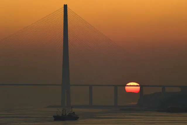 Sunrise over Russky Bridge across the Eastern Bosphorus Strait off Vladivostok on Russia's Pacific Coast on January 15, 2020. (Photo by Yuri Smityuk/TASS)