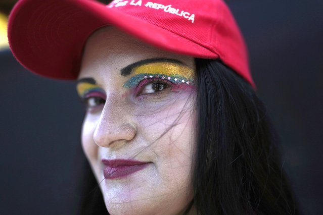 A government supporter poses for a photo during a rally marking May Day, or International Workers' Day in Caracas, Venezuela, Sunday, May 1, 2022. (Photo by Ariana Cubillos/AP Photo)