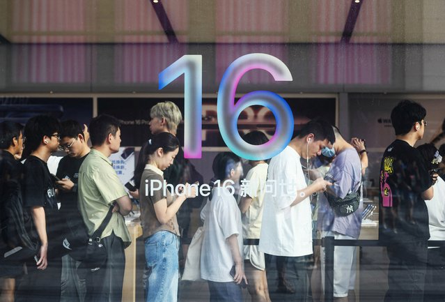 People line up to purchase newly-launched newly-launched iPhone 16 mobile phones at an Apple store in Hangzhou, in China's eastern Zhejiang province on September 20, 2024. (Photo by AFP Photo/China Stringer Network)