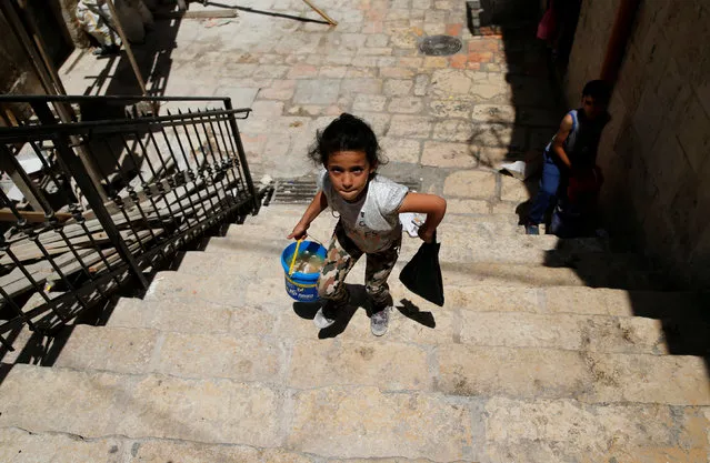 A Palestinian girl walks after she received a pack of food in the Old City of Jerusalem during the Muslim holy month of Ramadan June 22, 2016. (Photo by Ammar Awad/Reuters)