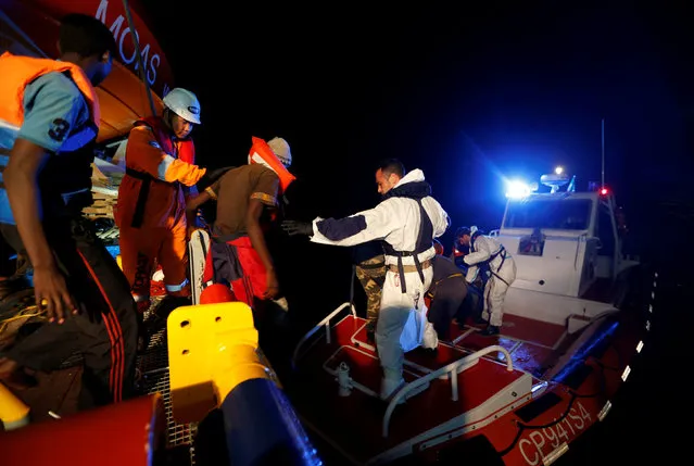Migrants are transferred from the Migrant Offshore Aid Station (MOAS) ship Topaz Responder to an Italian Coast Guard vessel after being rescued around 20 nautical miles off the coast of Libya, June 23, 2016. (Photo by Darrin Zammit Lupi/Reuters)