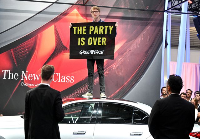 A Greenpeace protestor holds a banner during the 2023 Munich Auto Show IAA Mobility, in Munich, Germany on September 5, 2023. (Photo by Angelika Warmuth/Reuters)