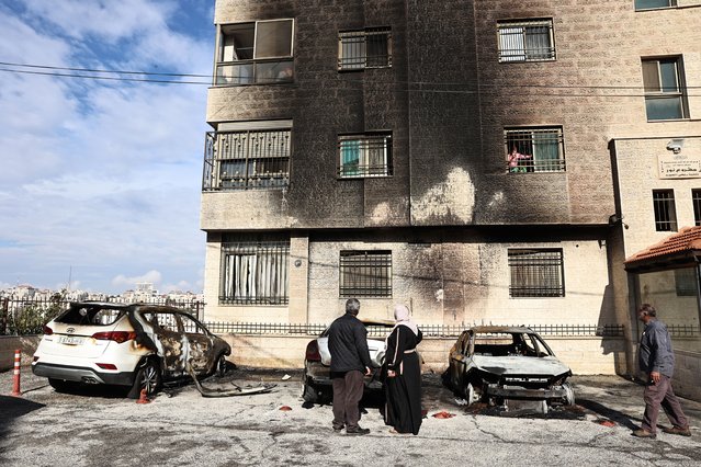 People inspect burnt cars and a building after a reported attack by Israeli settlers on the outskirts of Ramallah city in the occupied West Bank on november 4, 2024. (Photo by Zain Jaafar/AFP Photo)