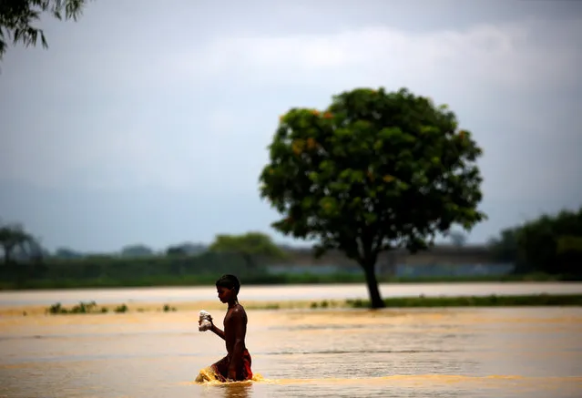 A boy walks along the flooded area in Saptari District, Nepal August 14, 2017. (Photo by Navesh Chitrakar/Reuters)