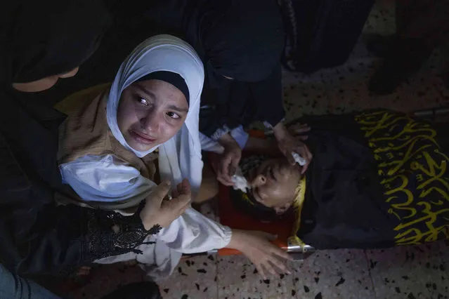 A mourner cries while she takes the last look at the body of Dherar al-kafrini, 17 years old, at the family house during his funeral in the West Bank refugee camp of Jenin, Tuesday, August 2, 2022. Al-kafrini was killed and another Palestinian wounded during an Israeli military raid late Monday in the occupied West Bank city of Jenin, the Palestinian Health Ministry said. (Photo by Nasser Nasser/AP Photo)