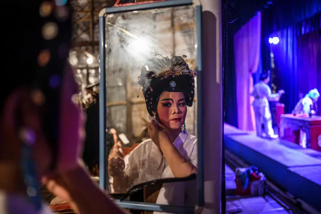 A Chiu Chow opera actor prepares for a performance during an event to mark the Hungry Ghost Festival in Hong Kong on September 11, 2017. The festival, celebrated in the seventh lunar month of the lunar new year calendar among communities in southern China, Malaysia, Singapore, Hong Kong and Taiwan, marks the belief that the “Gates of Hell” are opened to let out the hungry ghosts who then wander in the land of the living while foraging for food. During the festival, food offerings are made while paper money and joss sticks are burnt outside homes to keep the spirits of dead ancestors happy and to bring good luck. (Photo by Anthony Wallace/AFP Photo)