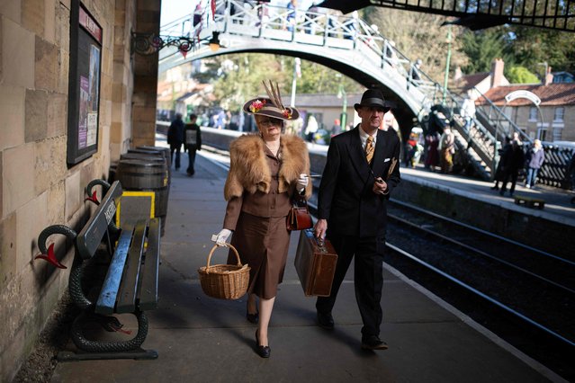 1940s reenactors wait on the platform of Pickering Station as they take part in a reenactment-themed weekend, “Through the Decades” event held along the North Yorkshire Moors Railway, in Pickering, northern England on October 14, 2023. The reenactment weekend invites attendees to dress in the styles of the 1940s, 1950s, 1960s, and 1970s and takes place at the stations along line of the 187 year old North Yorkshire Moors Railway. (Photo by Oli Scarff/AFP Photo)