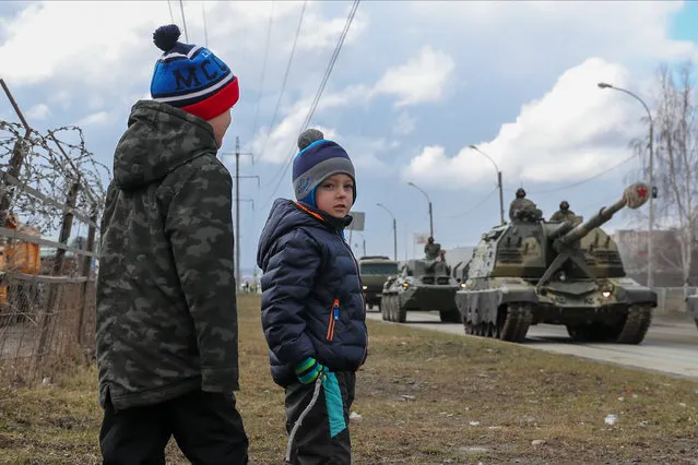 Boys watch Msta-S self-propelled howitzers passing by during a rehearsal of a military parade to be held on May 9 and mark the 75th anniversary of the victory in World War II in Yekaterinburg, Russia on April 14, 2020. (Photo by Donat Sorokin/TASS)