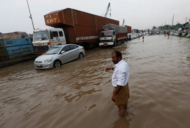 A man directs the vehicles in a waterlogged highway after heavy rains in Gurugram, previously known as Gurgaon, on the outskirts of New Delhi, India, July 29, 2016. (Photo by Adnan Abidi/Reuters)