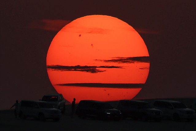 Desert goers watch the sunset south of Doha, Qatar, on November 1, 2024. (Photo by Karim Jaafar/AFP Photo)