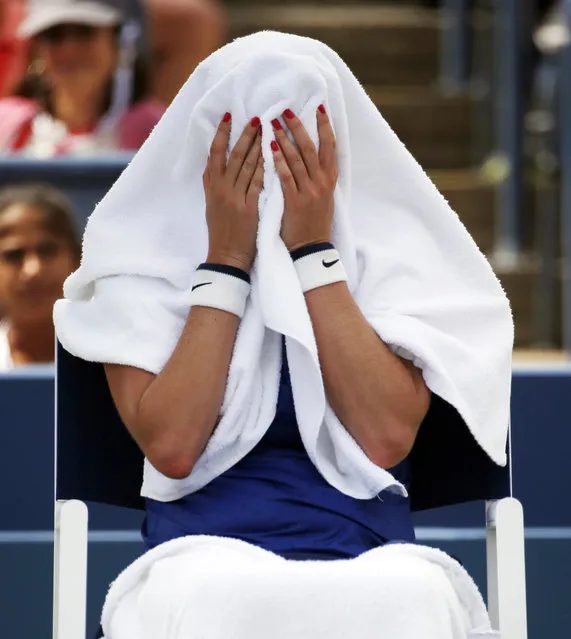 Petra Kvitova, of the Czech Republic, covers her head with a towel during a break between games against Aleksandra Krunic, of Serbia, during the third round of the 2014 U.S. Open tennis tournament, Saturday, August 30, 2014, in New York. (Photo by Kathy Willens/AP Photo)