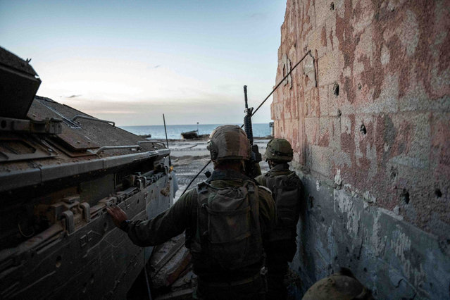 Israeli soldiers take position, amid the ongoing ground operation of the Israeli army against Palestinian Islamist group Hamas, in the Gaza Strip as seen in a handout picture released by the Israel Defense Forces on November 13, 2023. (Photo by Israel Defense Forces/Handout via Reuters)