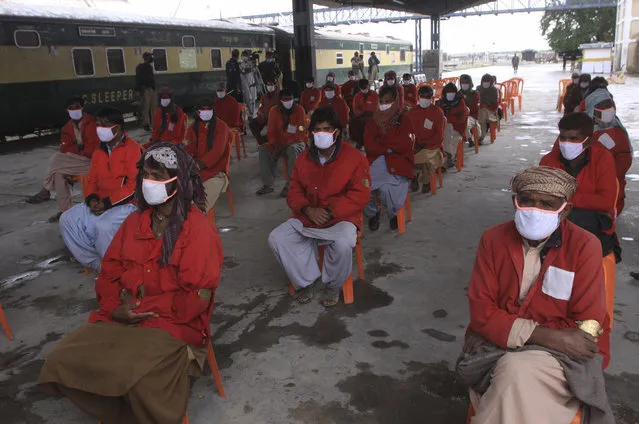 Workers wait to receive relief money as authorities suspended nation-wide railway service as a preventive measure against the outbreak of coronavirus, in Quetta, Pakistan, Friday, April 17, 2020. (Photo by Arshad Butt/AP Photo)