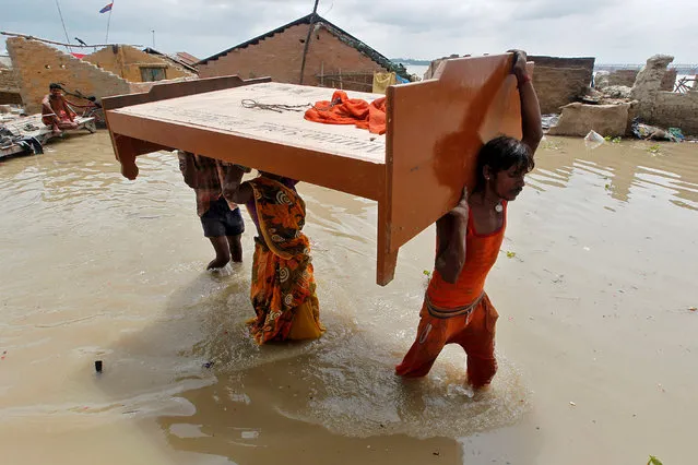 People remove a bed from their flooded house in Allahabad, India August 10, 2016. (Photo by Jitendra Prakash/Reuters)
