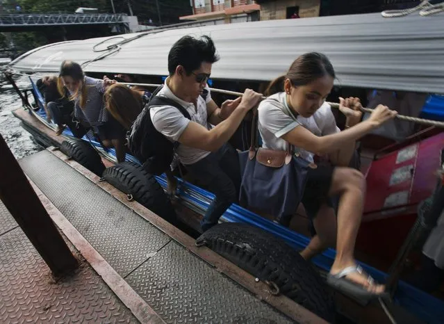 In this September 15, 2014, photo, commuters get off a motorized boat during rush hour on a pier at the Saen Saeb canal in Bangkok, Thailand. (Photo by Sakchai Lalit/AP Photo)